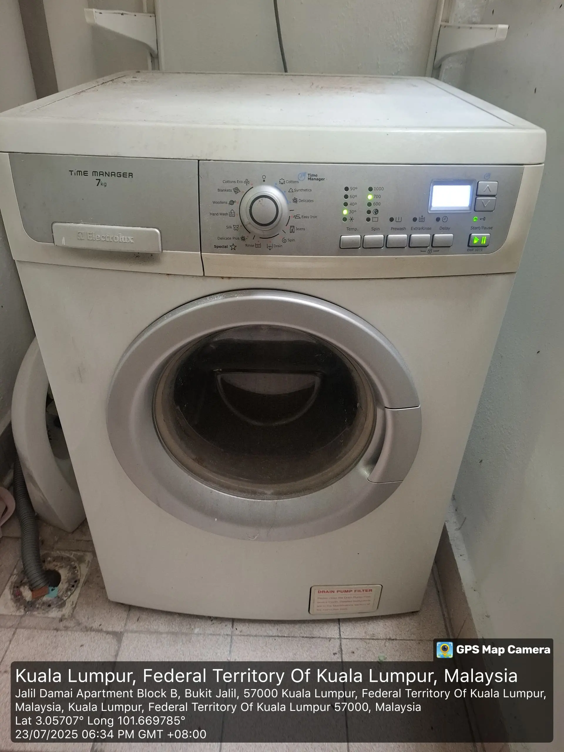 Technician checking washing machine electronics